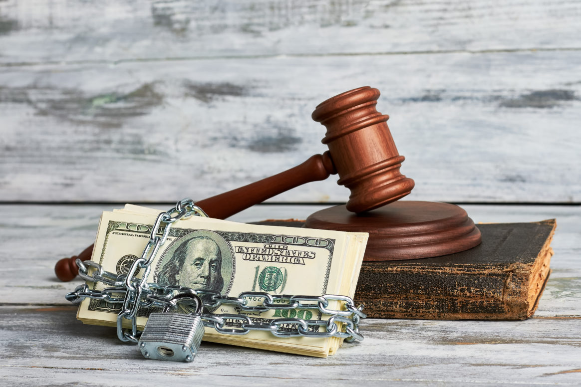 A gavel chained to money