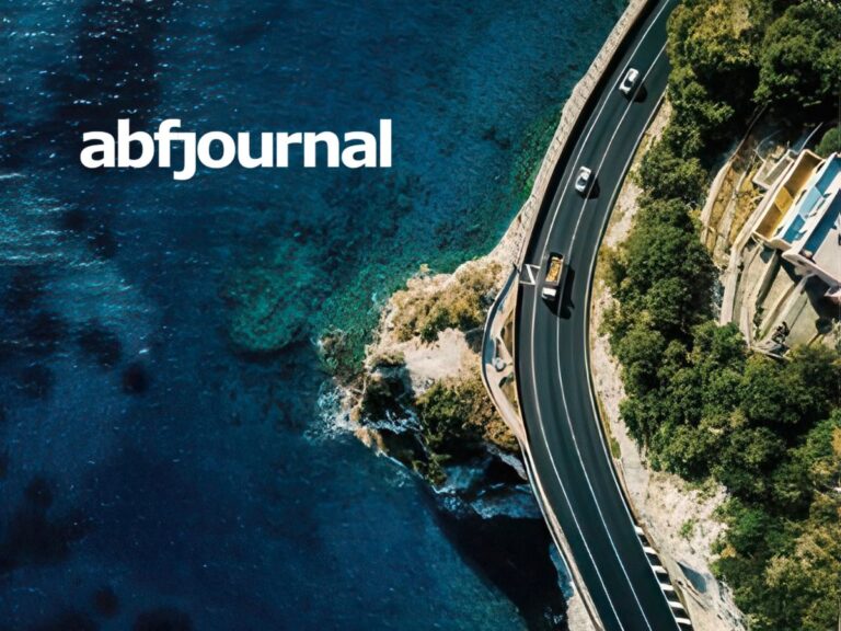 A white ABF Journal logo over an aerial view of a winding coastal road hugging a rocky shoreline, with several cars driving beside clear blue ocean water and cliffs lined with greenery.