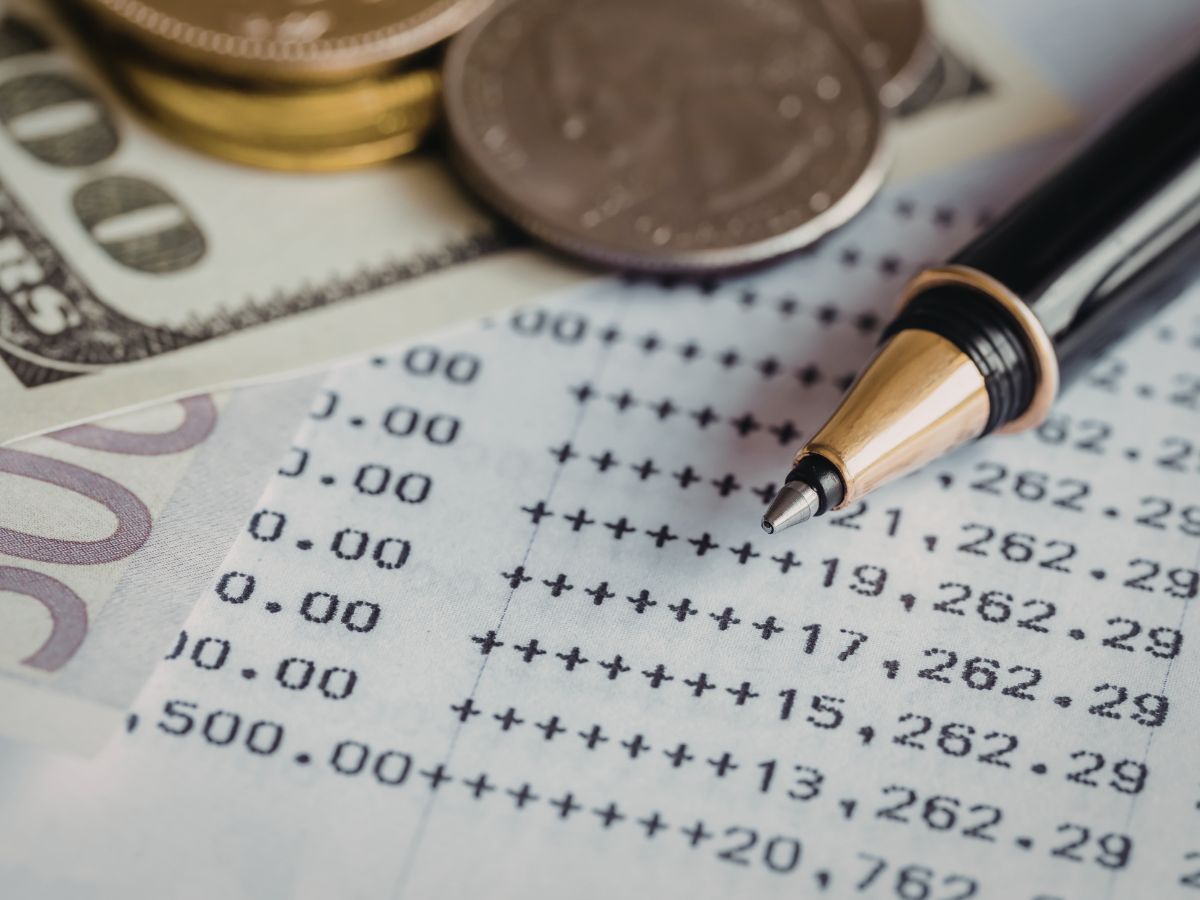 Claude responded: A business bank statement showing recurring daily withdrawals, with cash and a pen nearby, illustrating the cash flow pressure of merchant cash advance ACH deb…A business bank statement showing recurring daily withdrawals, with cash and a pen nearby, illustrating the cash flow pressure of merchant cash advance ACH debits